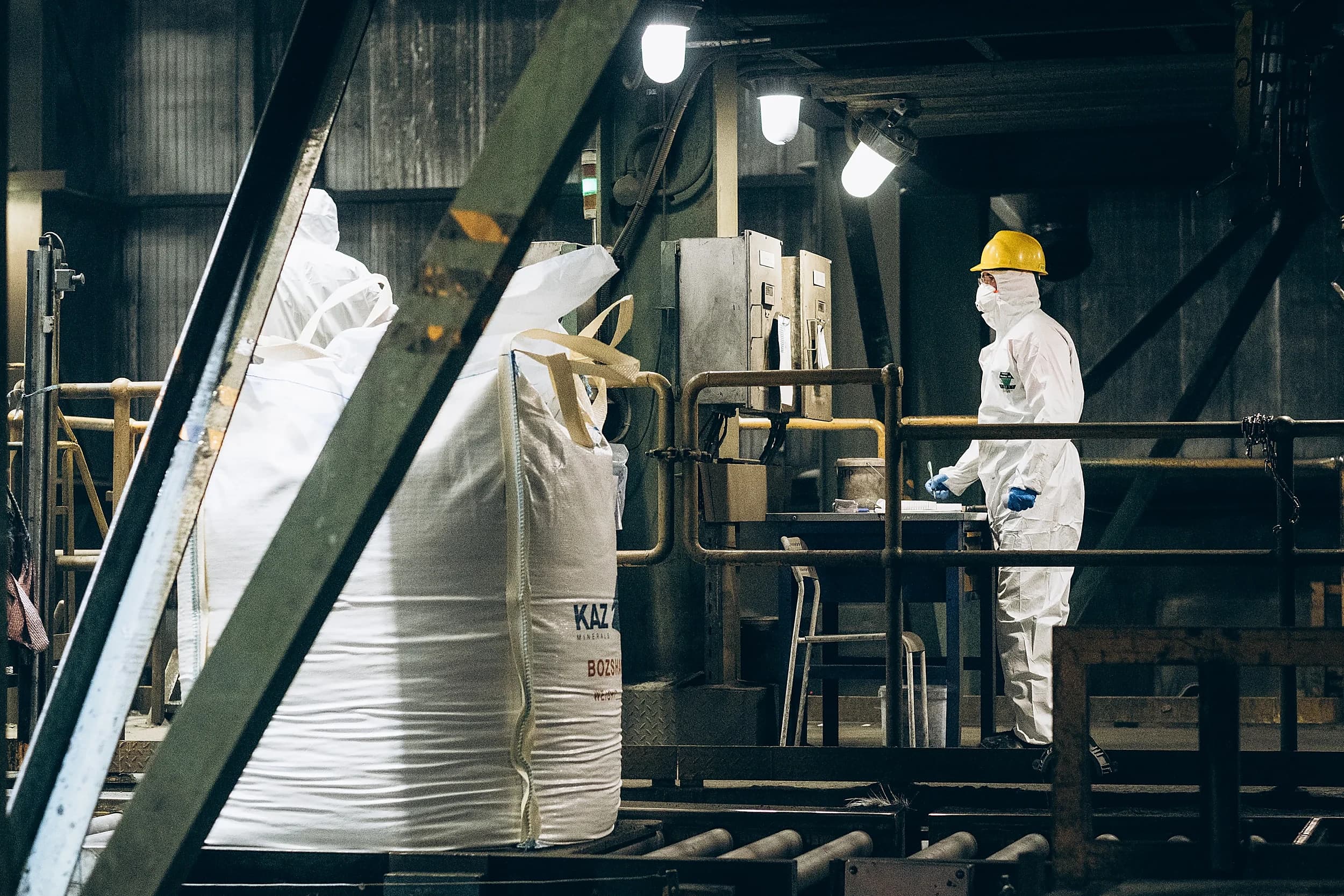 Worker in a protective suit at a bagging line, shot by the Artifact crew